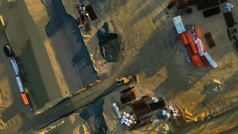 Aerial view of an active construction site with trucks and equipment