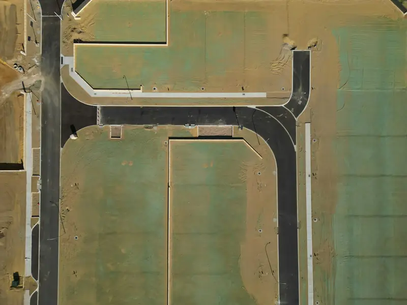 Top-down drone view of a new housing development with fresh streets and lots